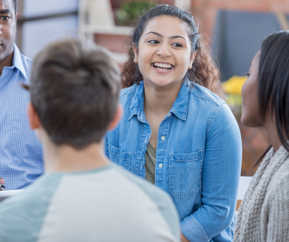 Hispanic female student speaking with peers