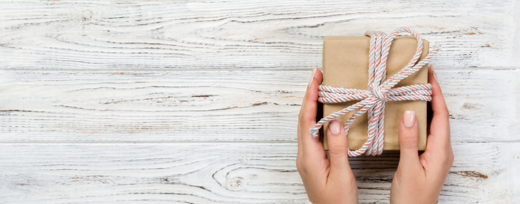 Hands presenting a gift box.