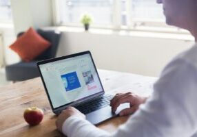person using macbook pro on table